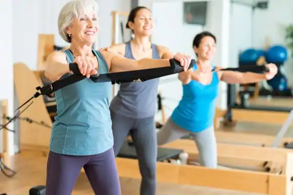 Toning Arms After 60: Empowering Womens Fitness Through Effective Weight Training 2 older woman doing weight training Banbury and resistance in the gym to tone upper arms