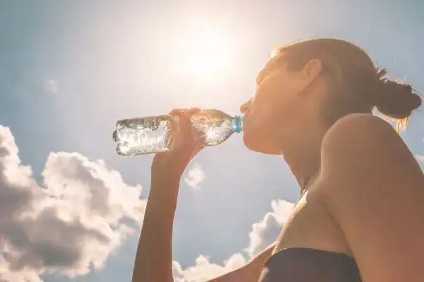 Hydration: The Secret Ingredient for a Toned Stomach and Enhanced Fitness 3 Image of woman drinking water to hydrate Banbury after run.